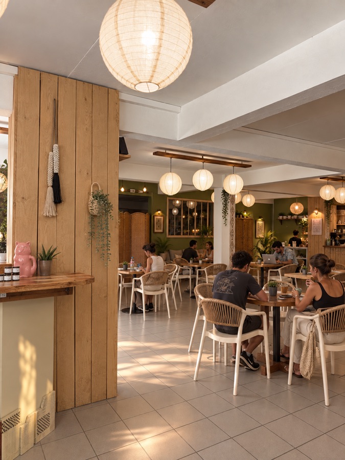 La salle vue du bar : tables en bois et lanternes en papier